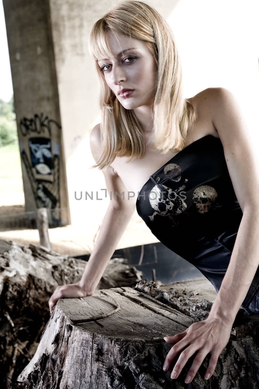 Fashion shoot of a woman on a tree stump