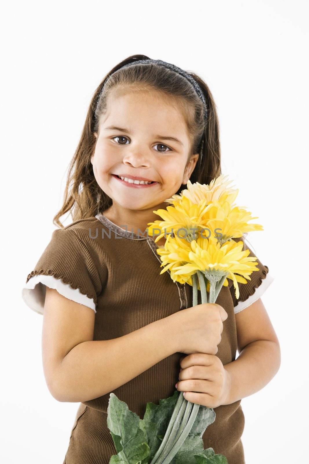 Cute little hispanic girl holding bouquet of yellow flowers.