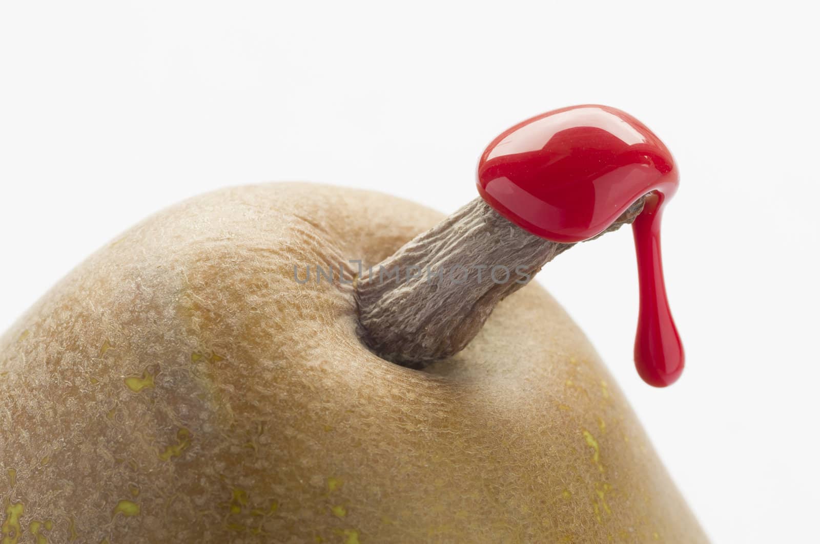 Green pear with red sealing wax on stalk