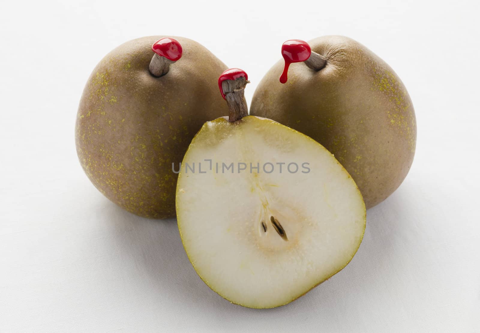 Green pears with red sealing wax on stalk