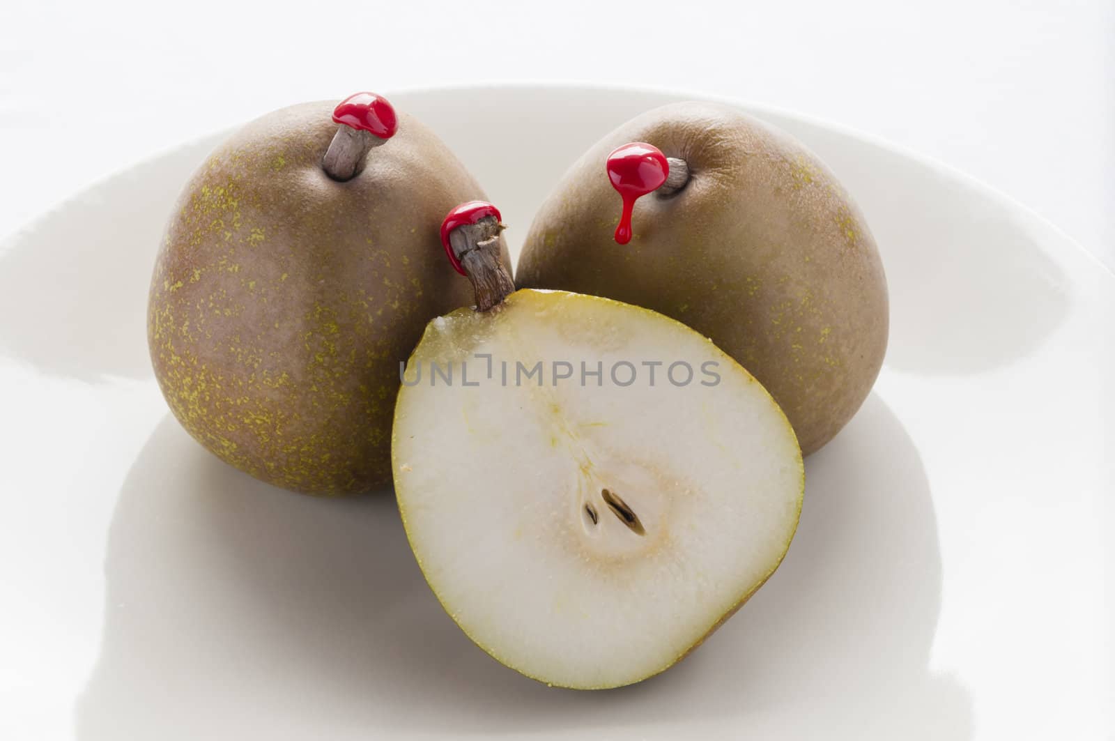 Green pears with red sealing wax on stalk