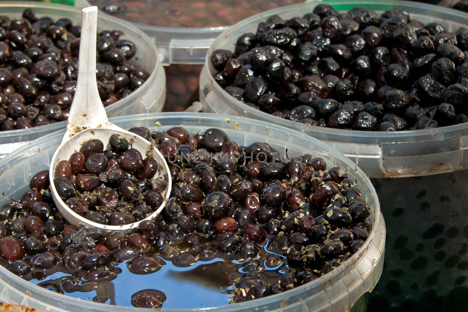 Black olives with spoon at the local market