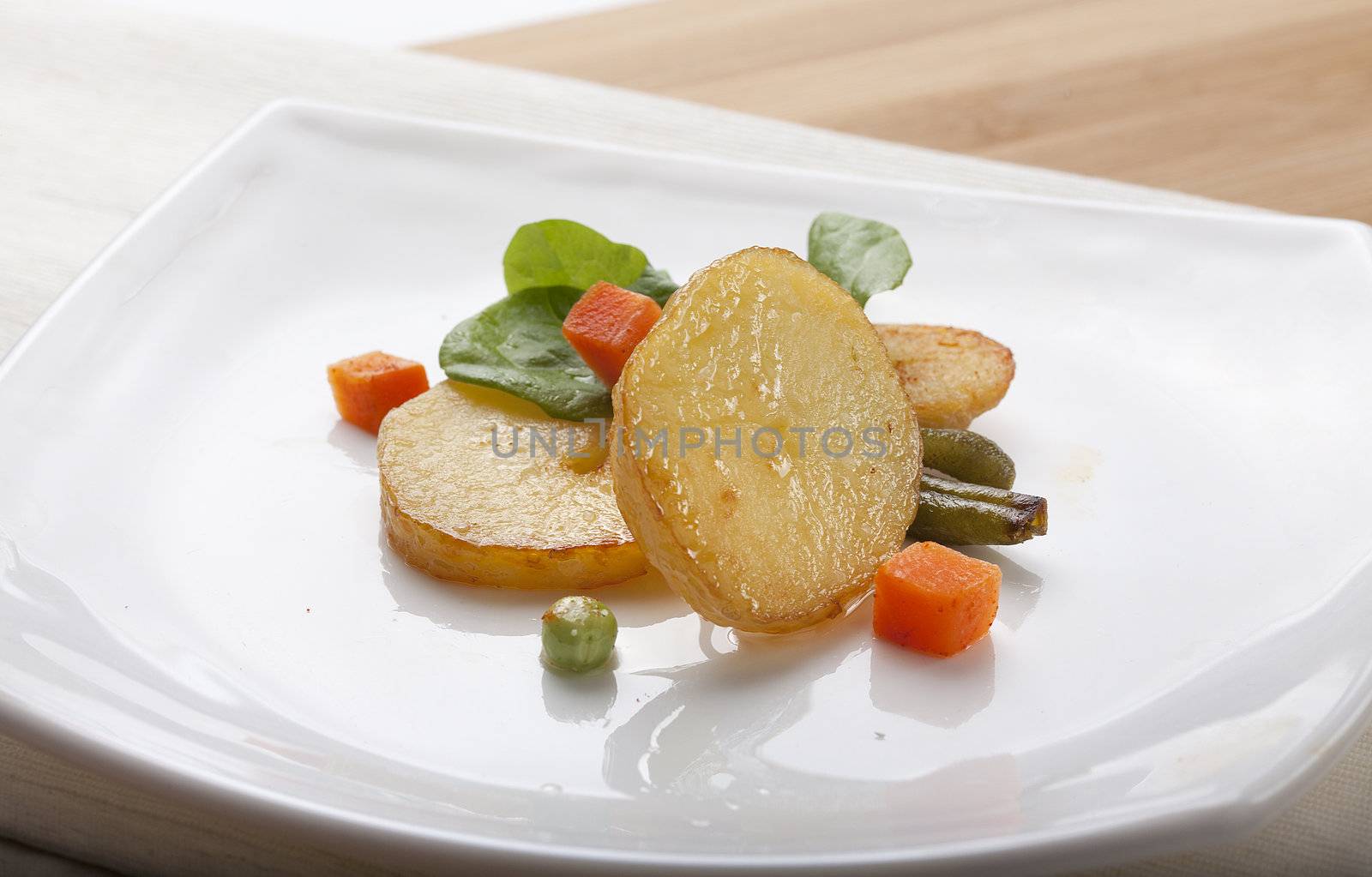 Fried potato with lettuce and vegetables on the white plate