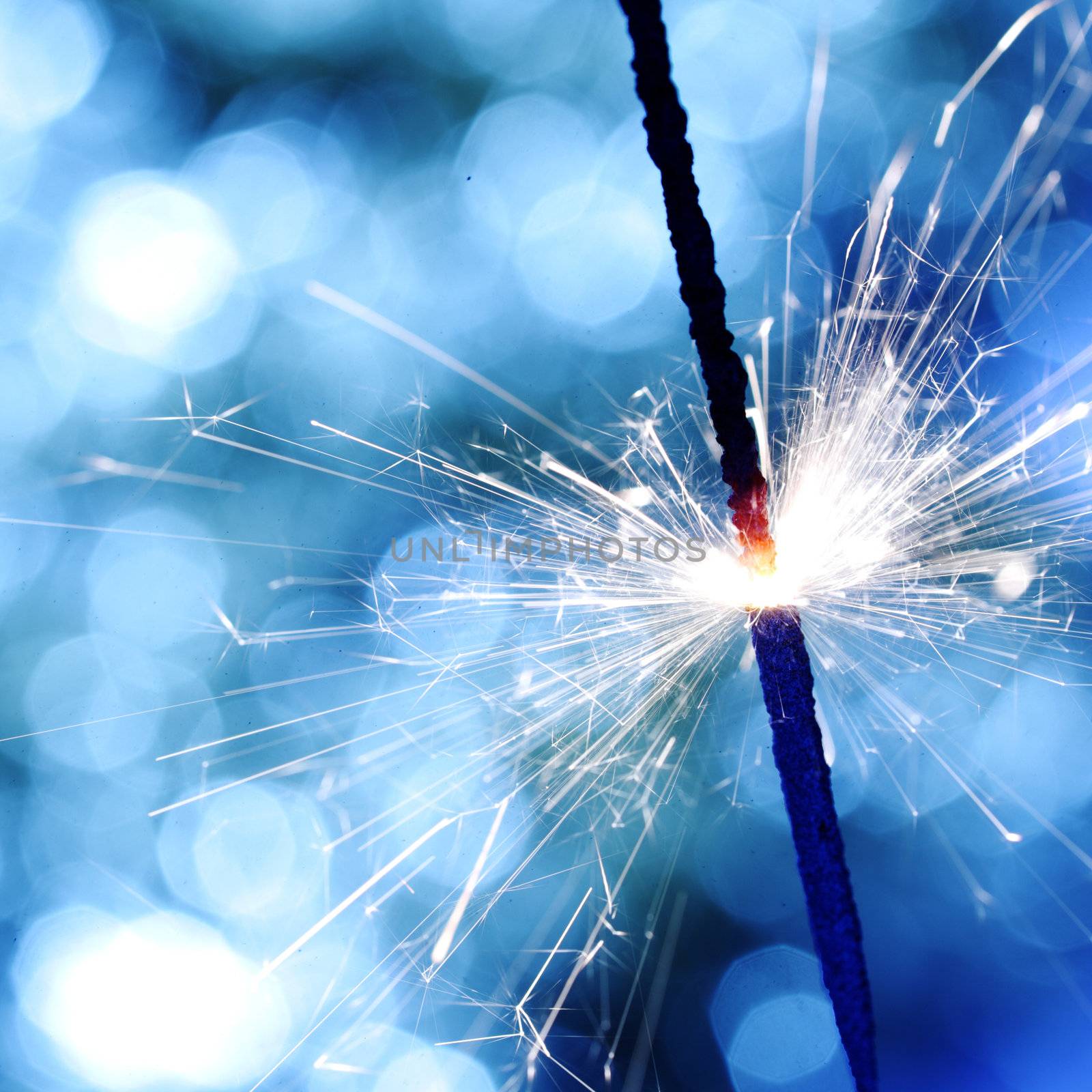 sparkler on blue bokeh background macro close up