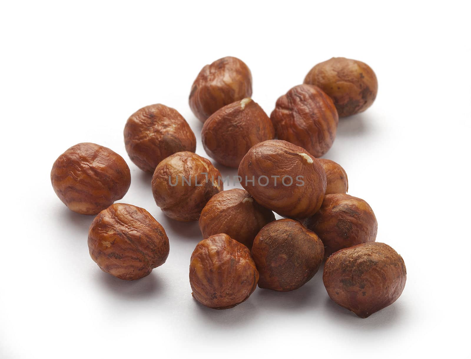 handful of brown hazelnuts on the white background