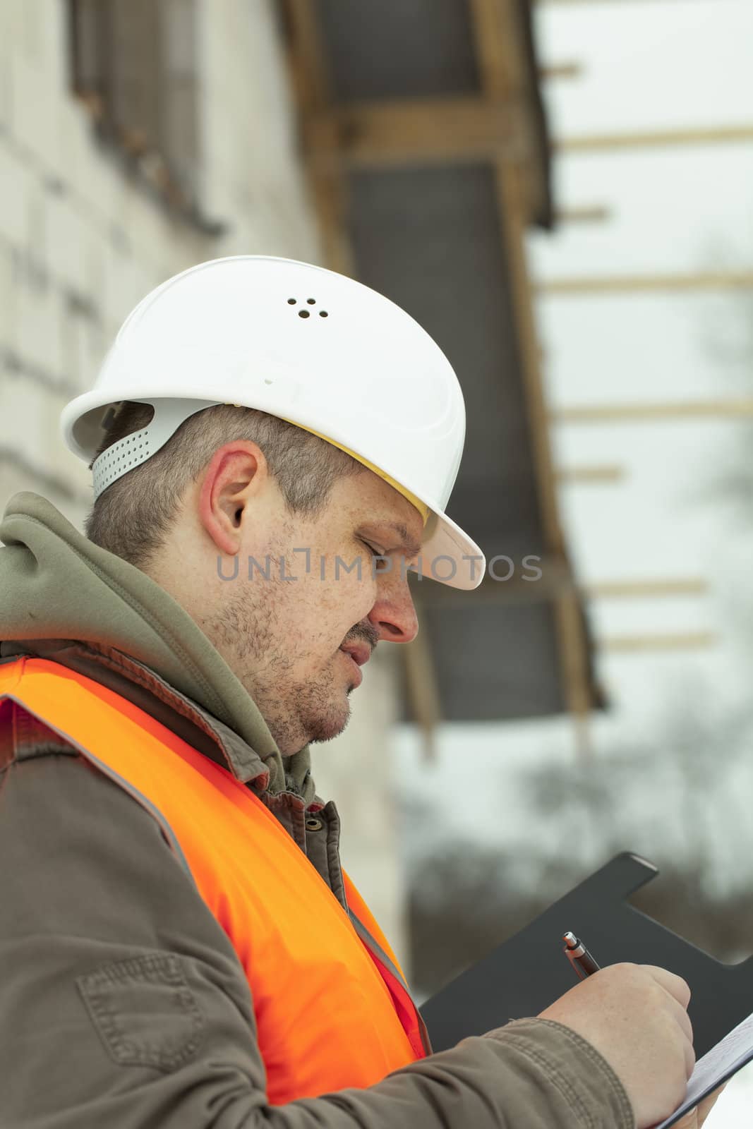 Engineer writing near new building