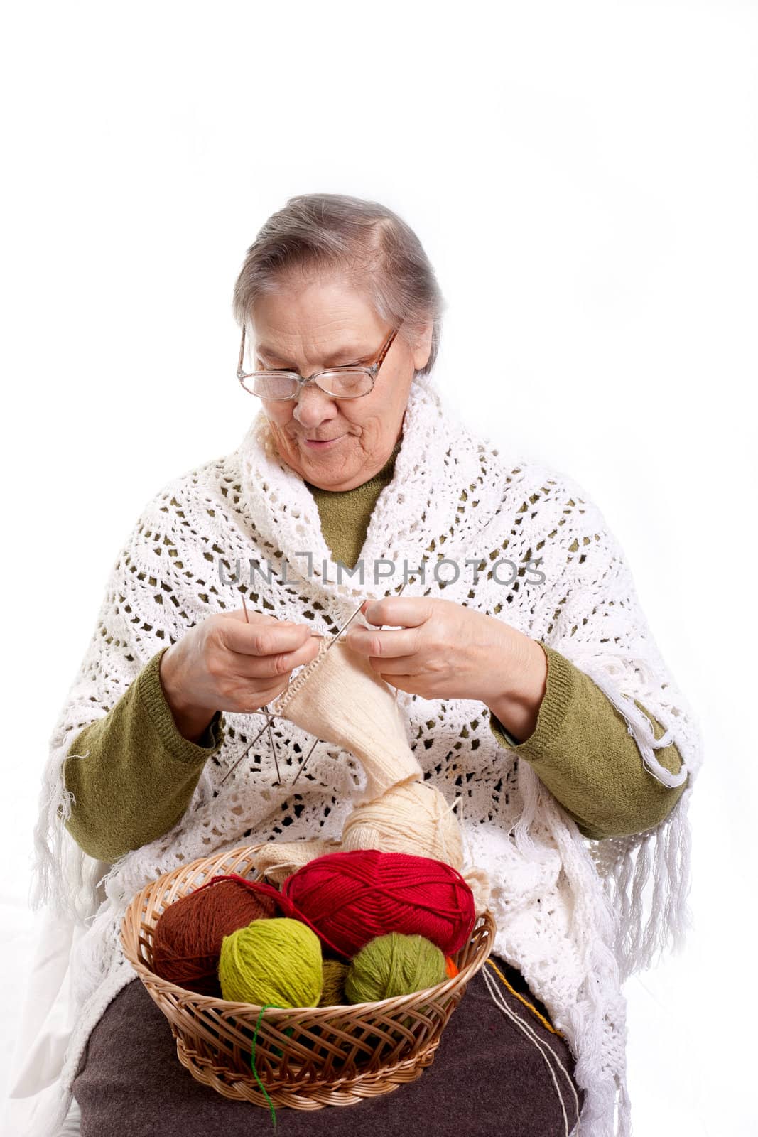 Senior woman knitting isolated on white background