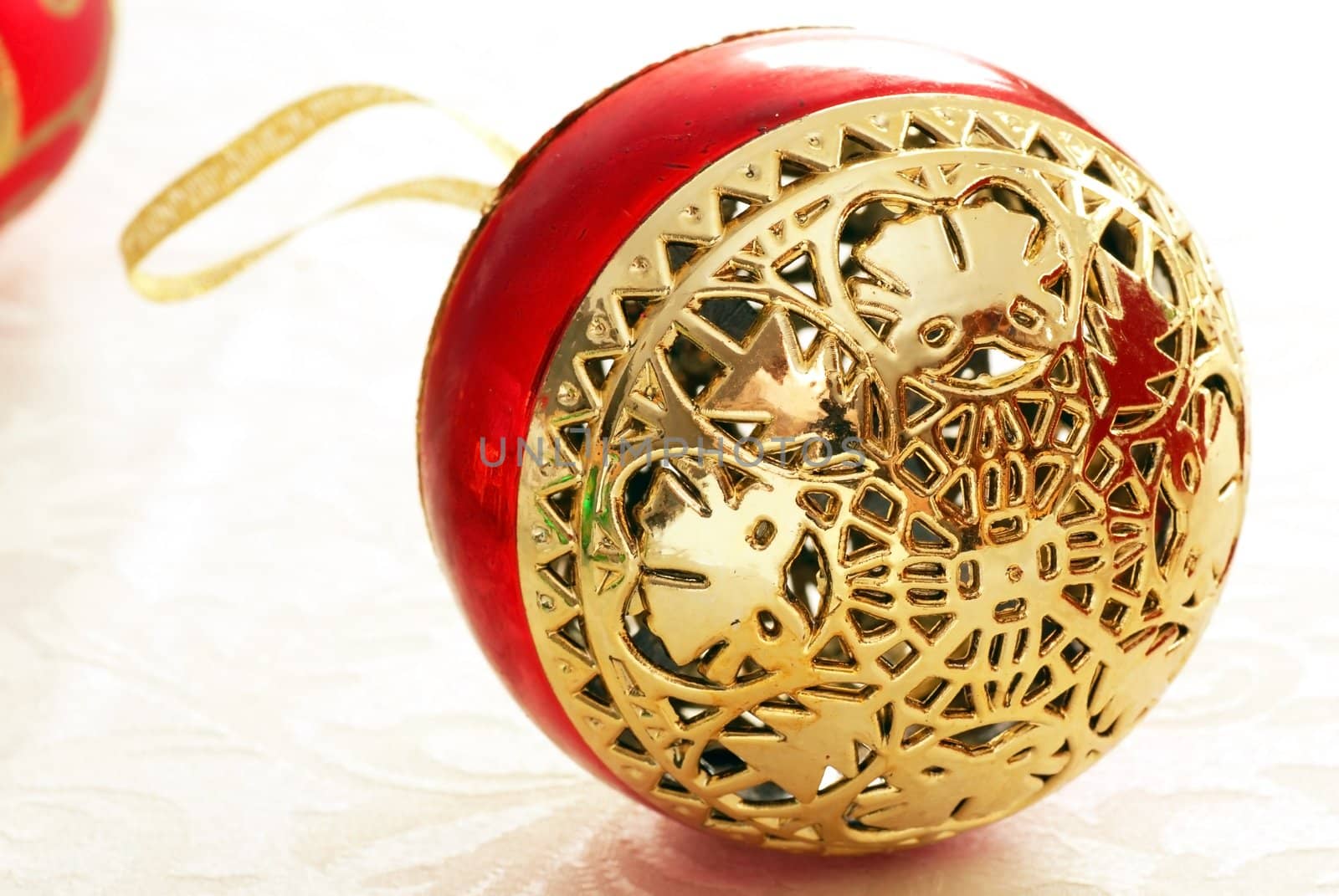 red christmas ball with golden details over white background macro