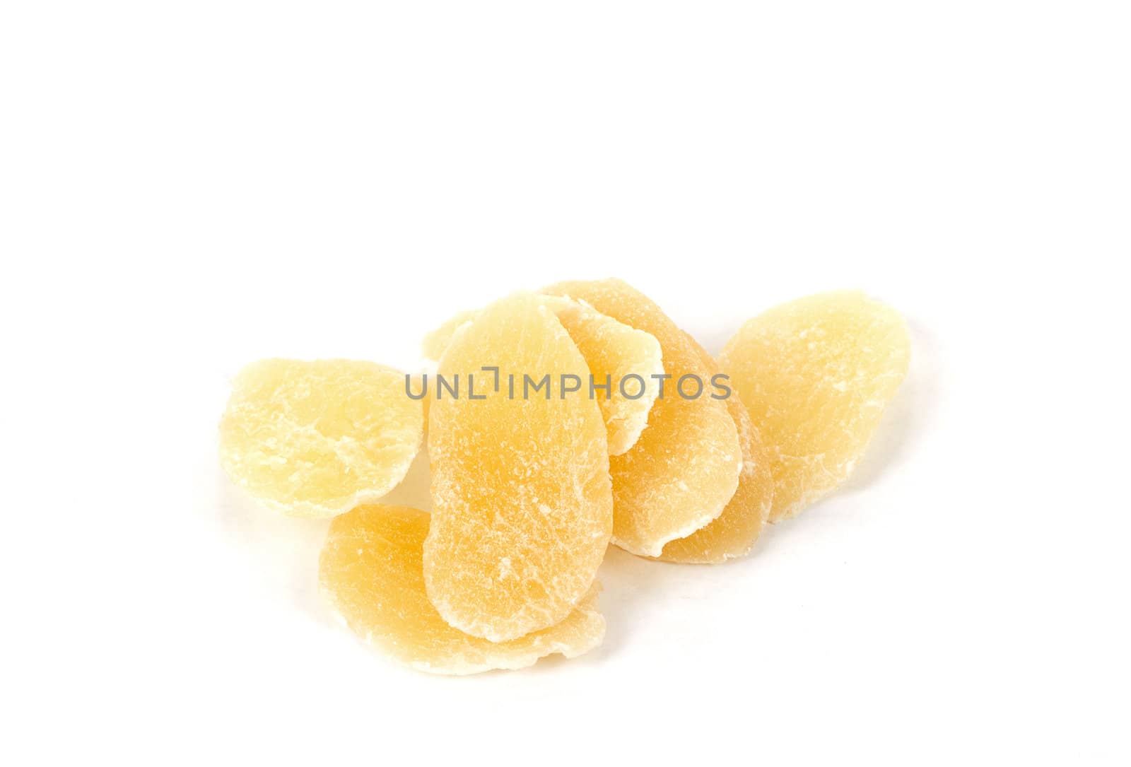 yellow dried mango slices on white background