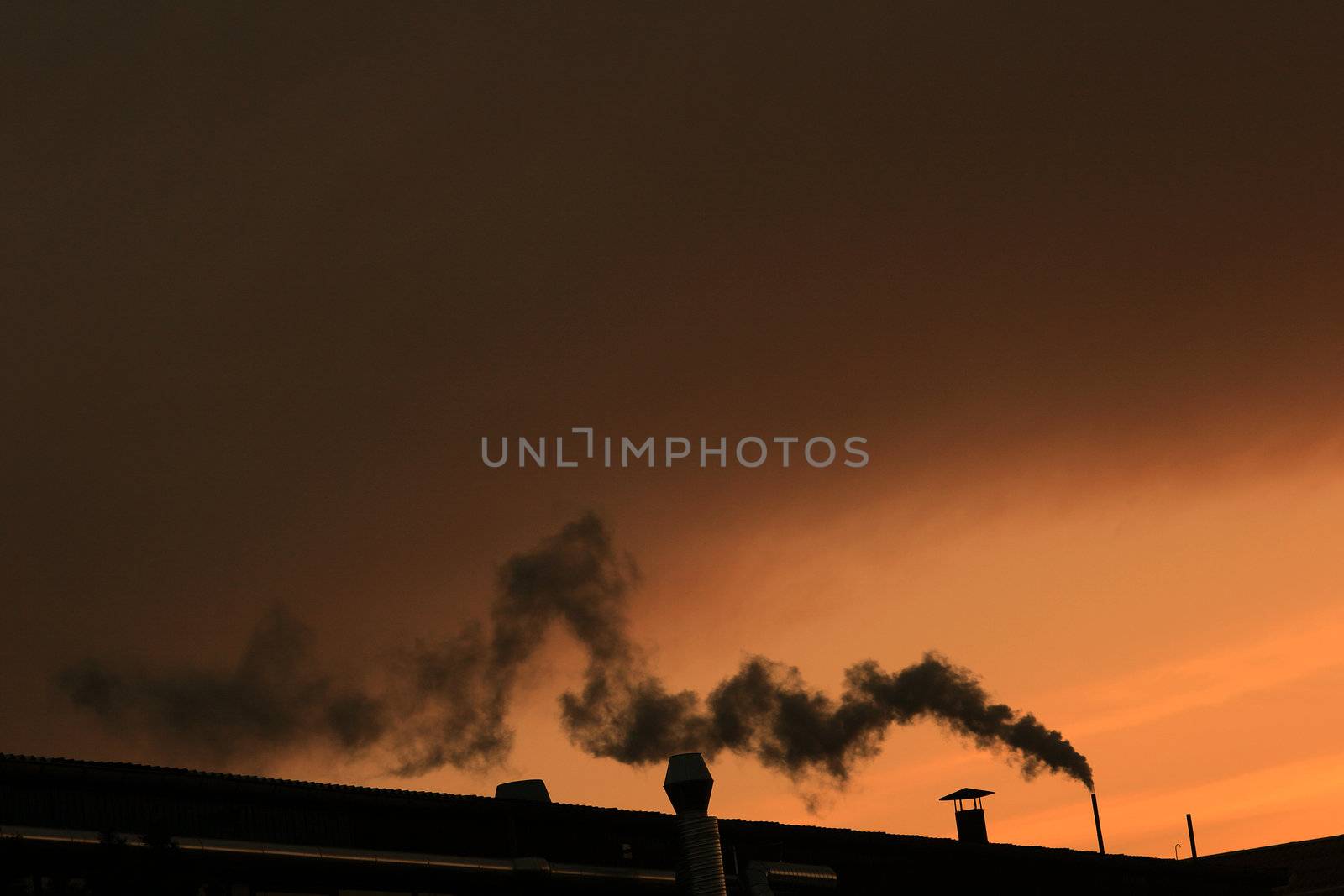 smoking chimney with a  warm orange sun
