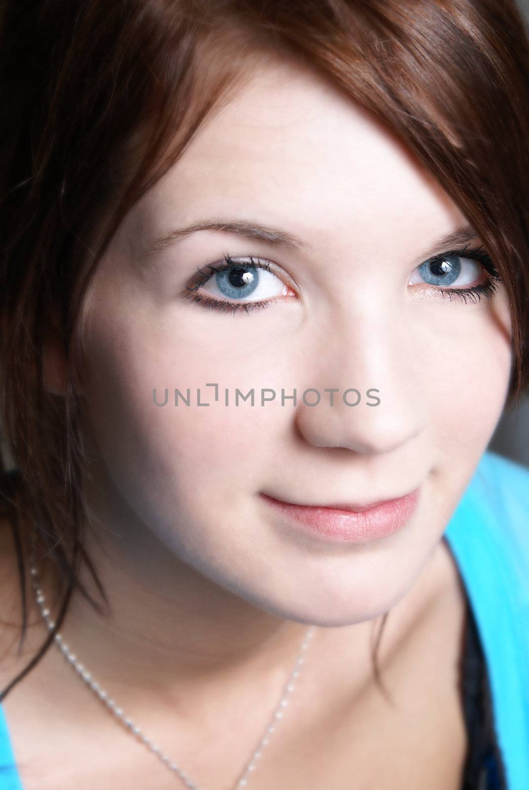 A closeup portrait of a young girl with big blue eyes.