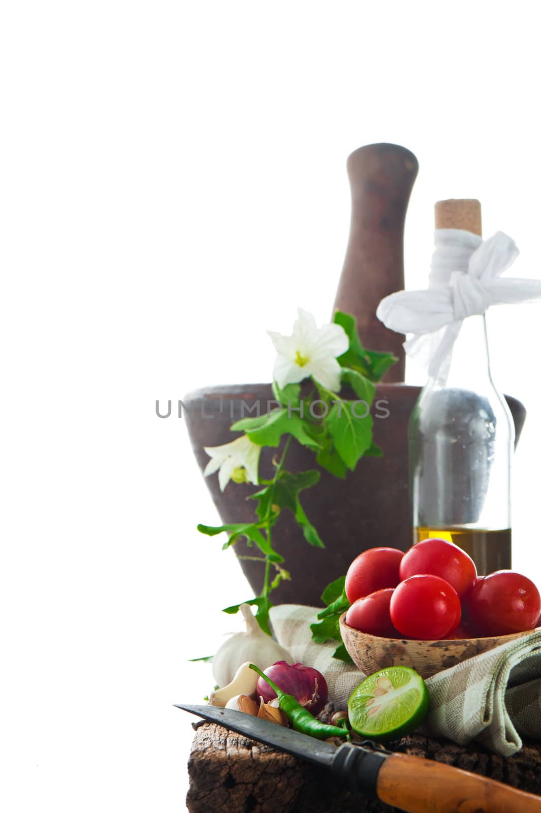 fresh vegetables and olive oil on an old weathered wood with a old mortar in behind over white background