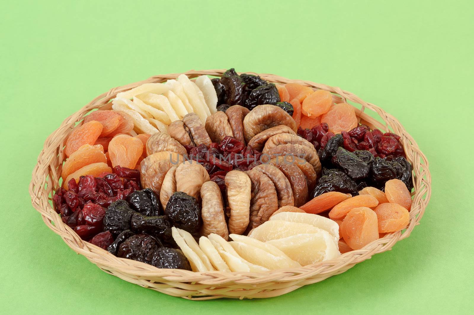 various dried exotic fruits on green background