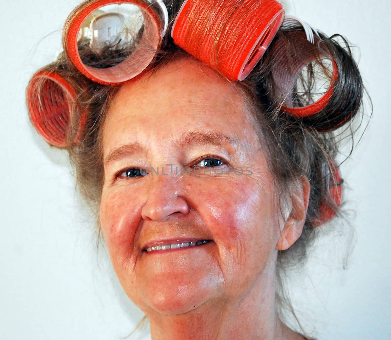 Mature female with big curlers in her hair.
