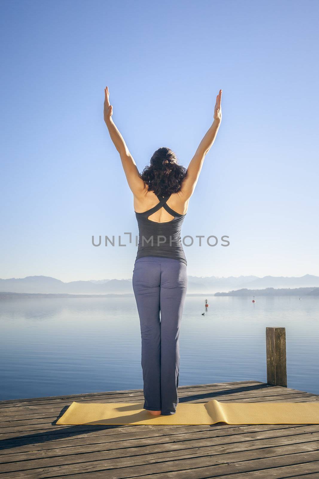 An image of a pretty woman doing yoga at the lake