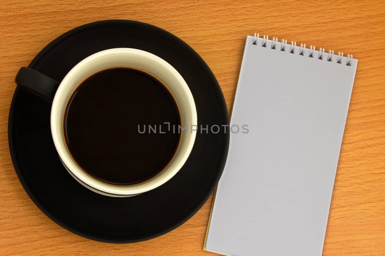 Coffee cup and white notebook
