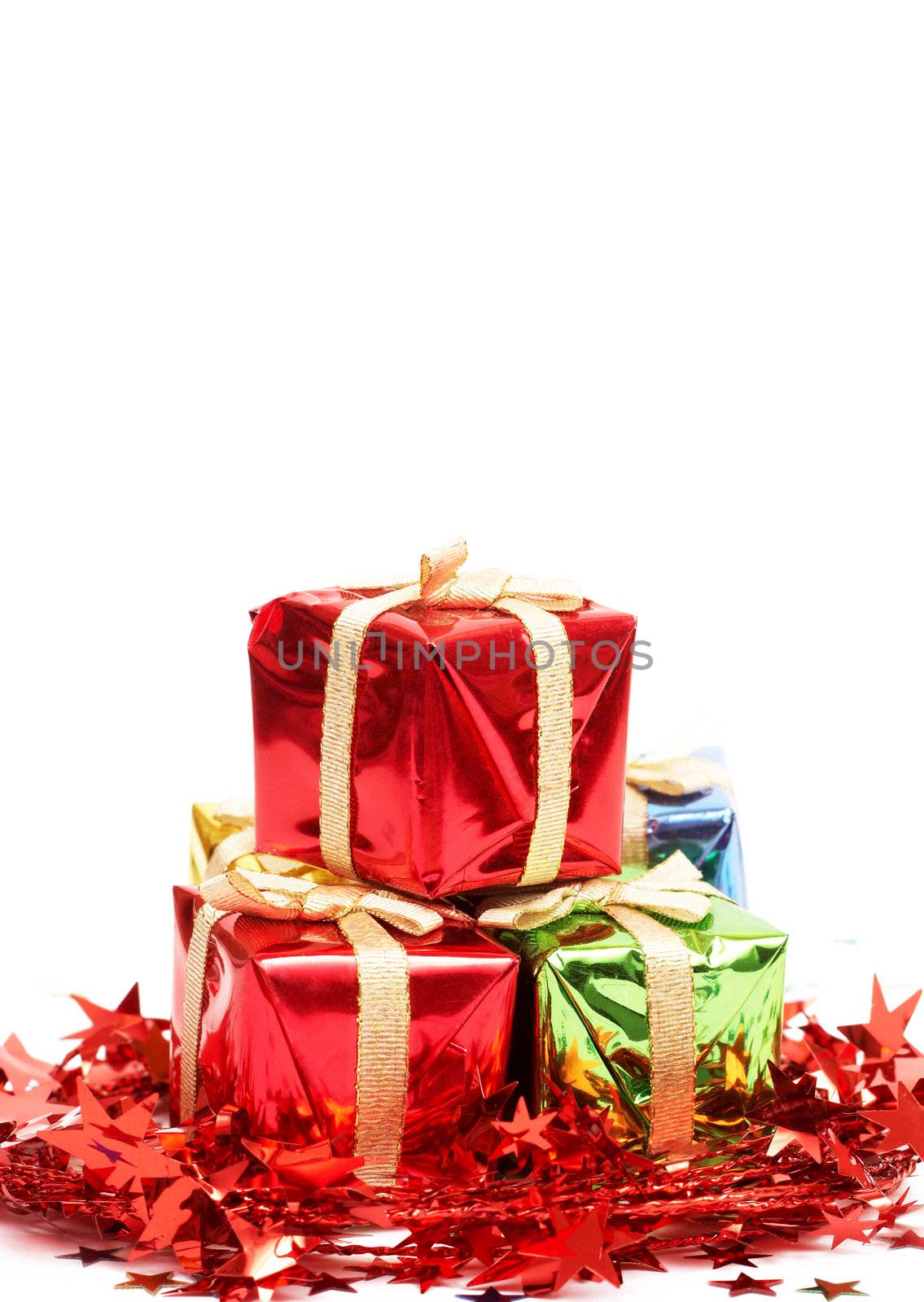 Stack of Christmas gift boxes and red tinsel isolated on white background with copy space. 