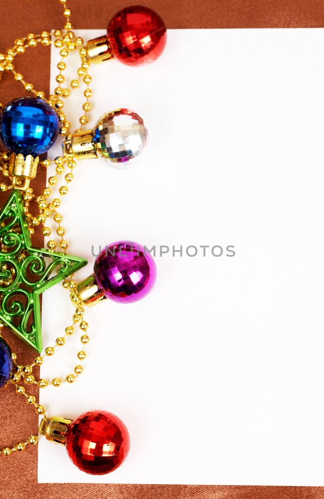 Colorful Christmas baubles, star and white card with copy space. 