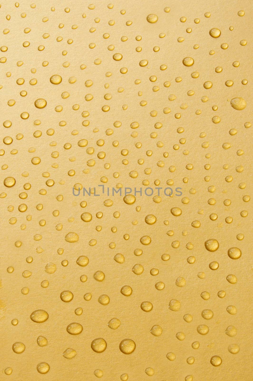 Closeup image of water droplets on a gold background