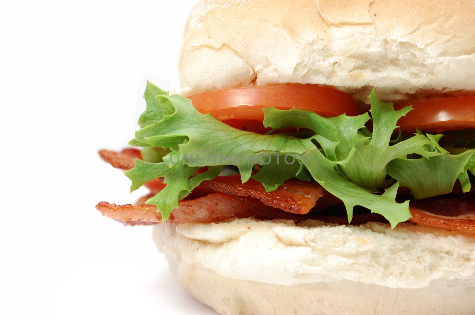 Closeup of a bacon roll with lettuce and tomatoes