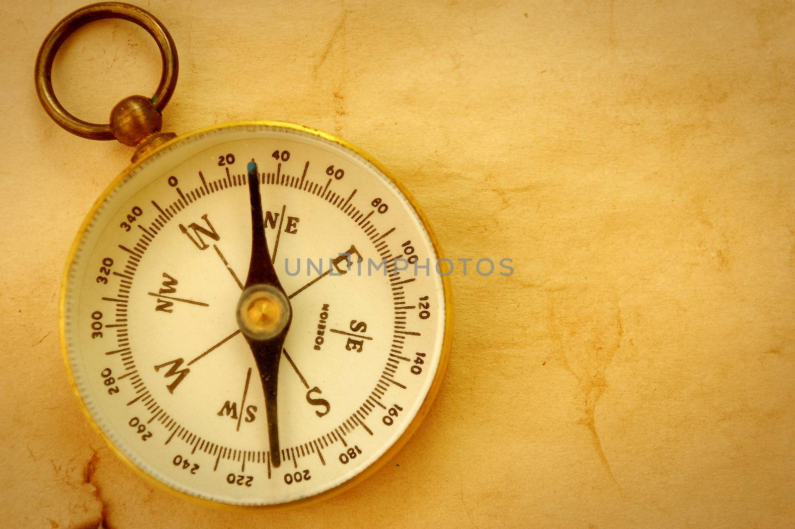 Vintage compass on an old textured paper background