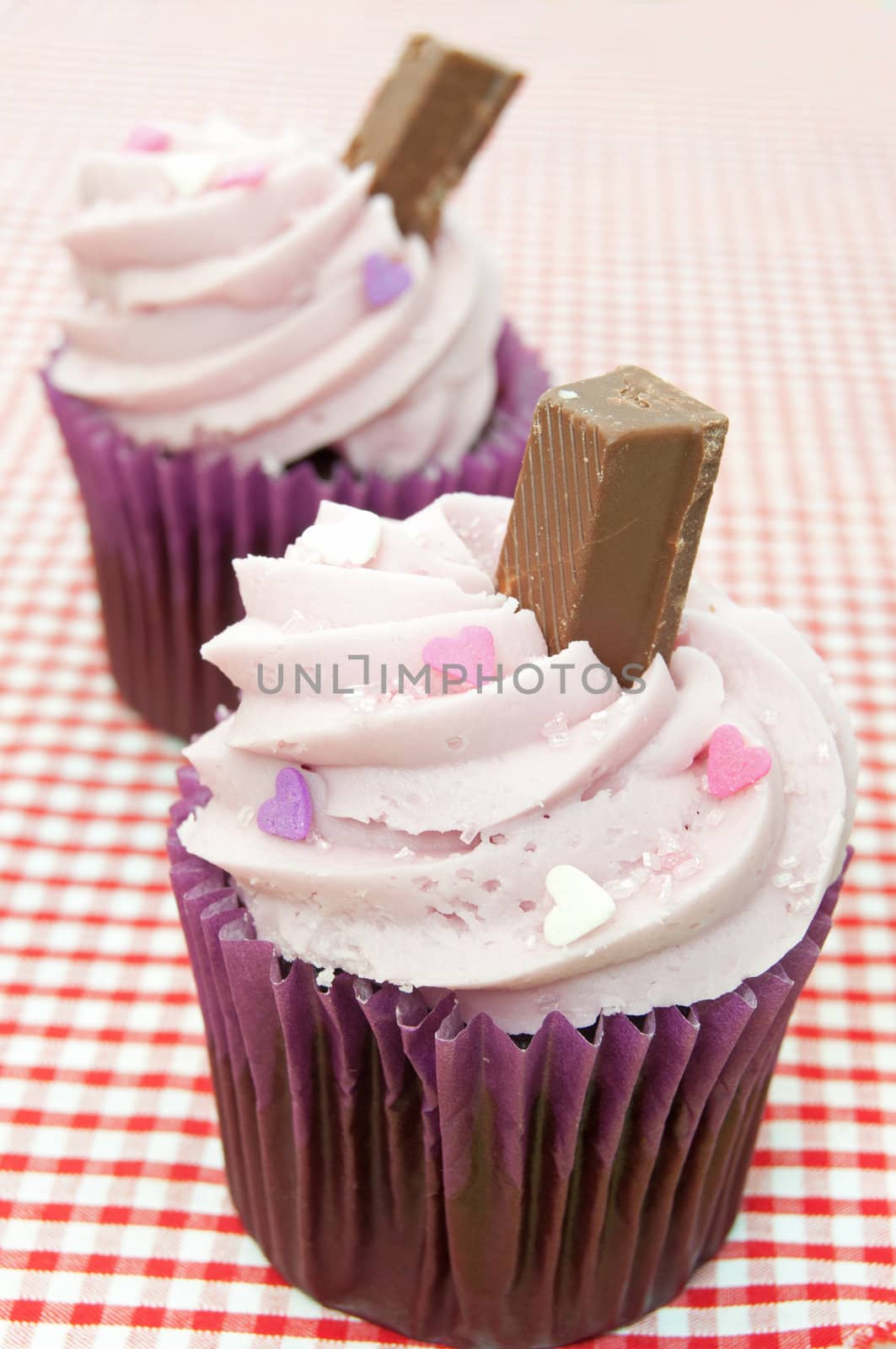 Creamy cupcakes with chocolate flakes and heartshaped sprinkles 