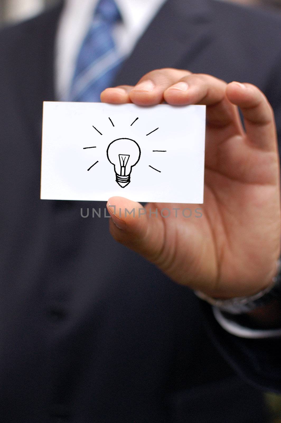 Business man holding out a blank card in his hand with a drawing of a bulb idea concept 