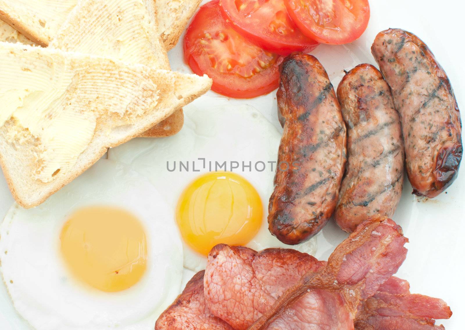 Closeup of a traditional english breakfast fry up with sausages, eggs and bacon