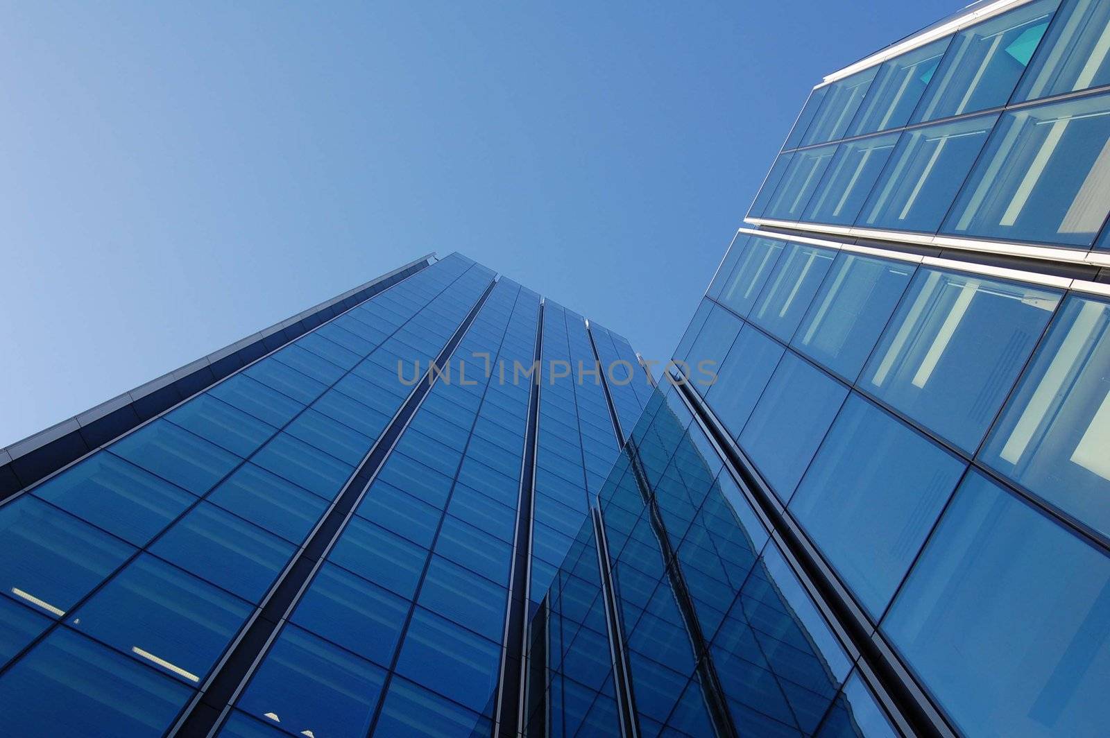 Large modern glass buildings against a blue sky