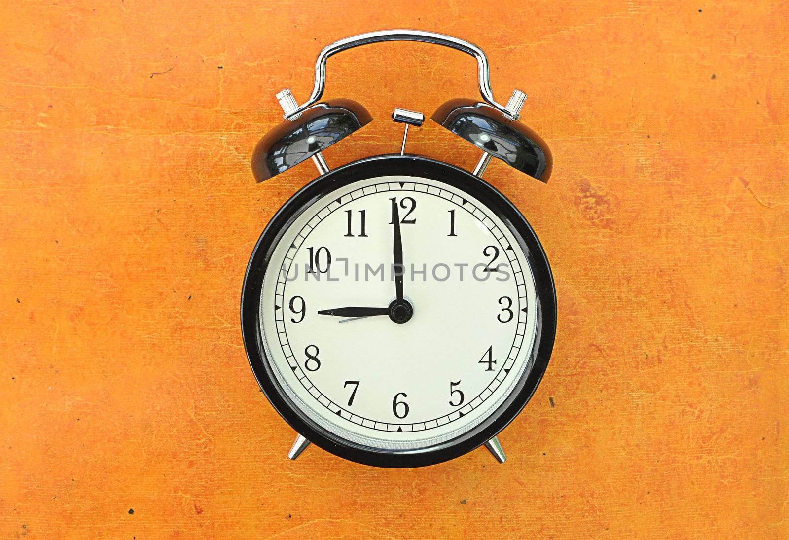 Closeup of an old vintage alarm clock face at 9 o'clock