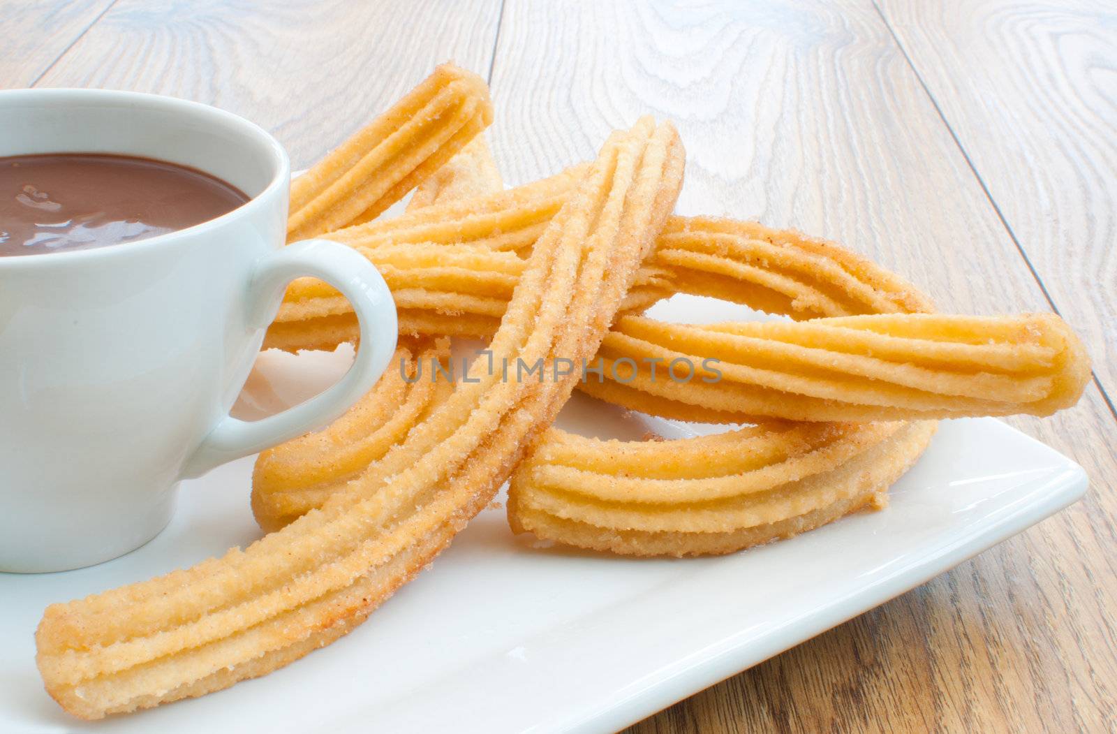 Traditional spanish churros with a cup of thick hot chocolate