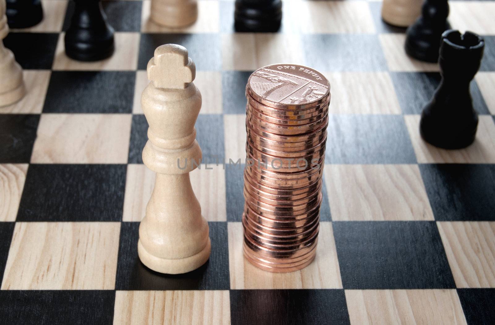 Chess king next to a heap of coins 