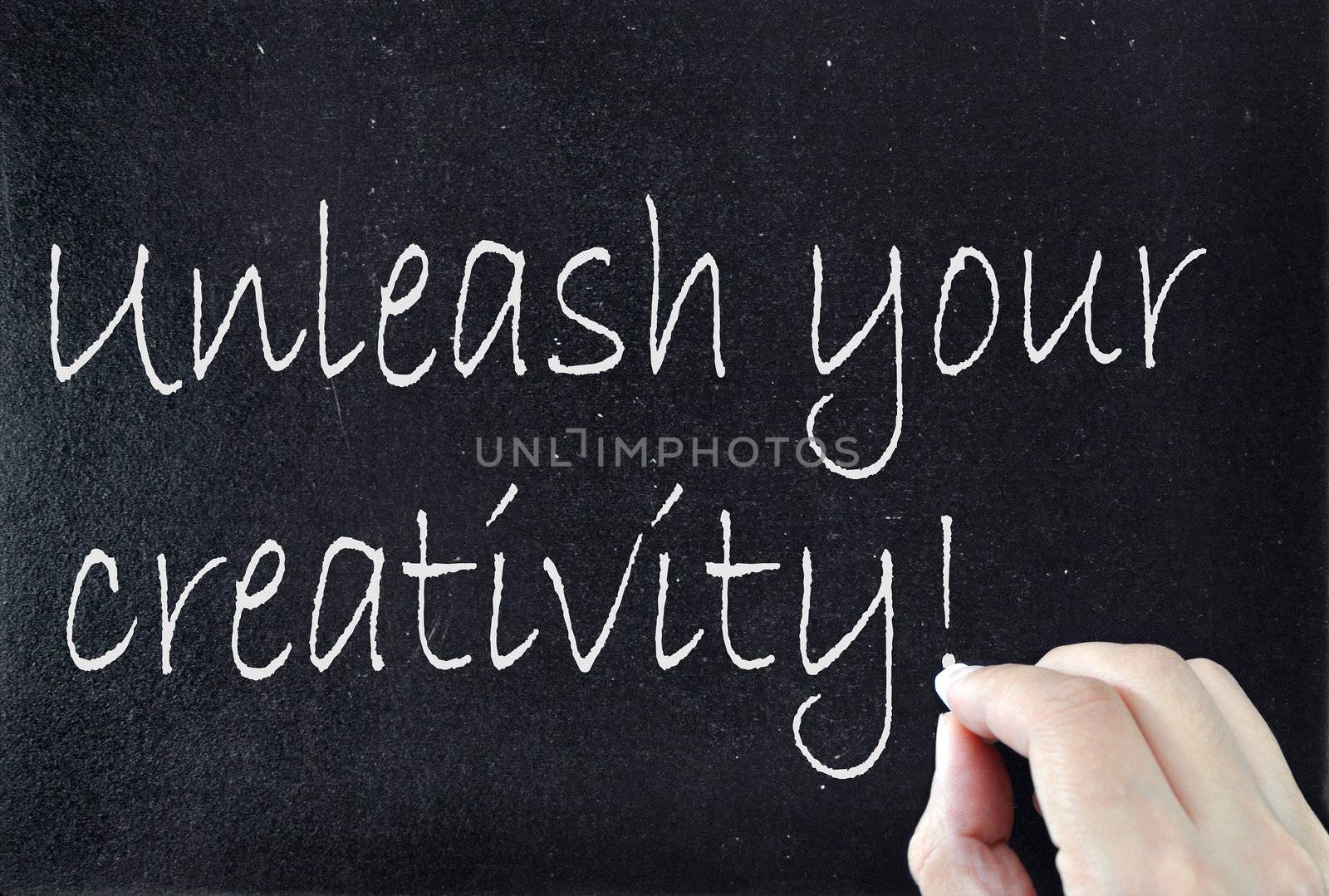 Unleash your creativity handwritten on a blackboard 