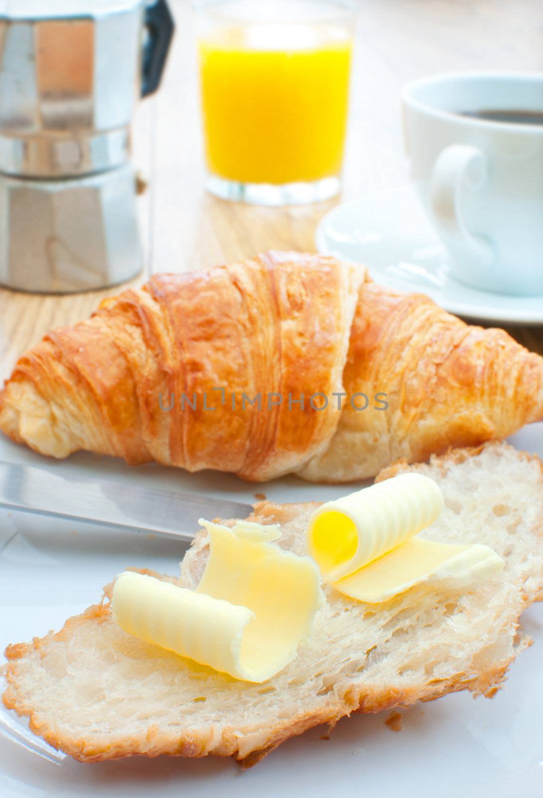 Croissant with butter, coffee and orange juice