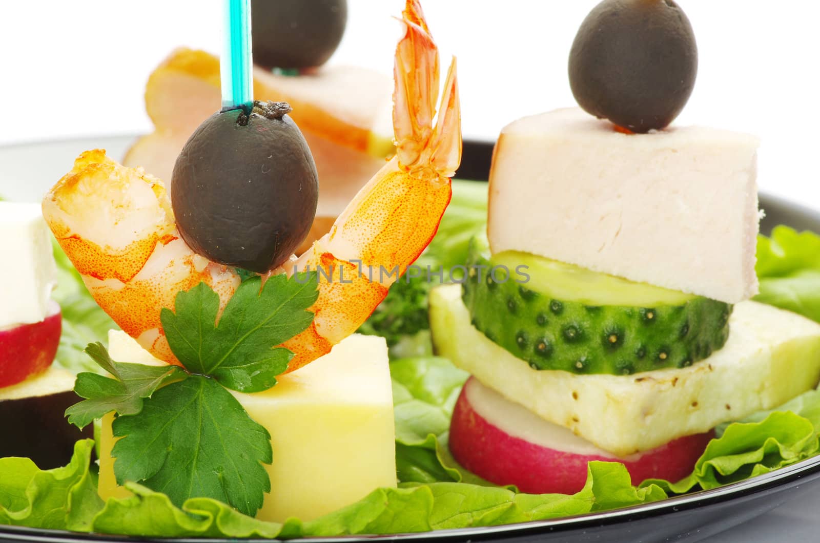 Close-up of canape with olives, cheese and over white