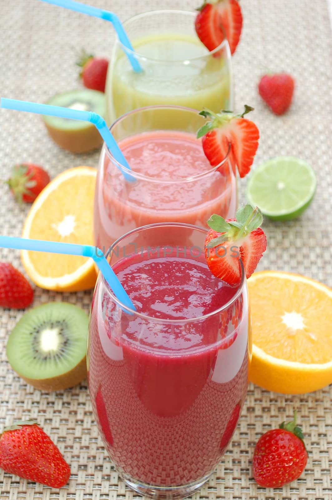Three smoothies and sliced fruit