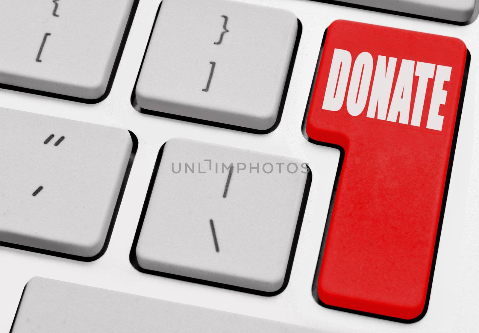 Donate printed on a red computer return key 