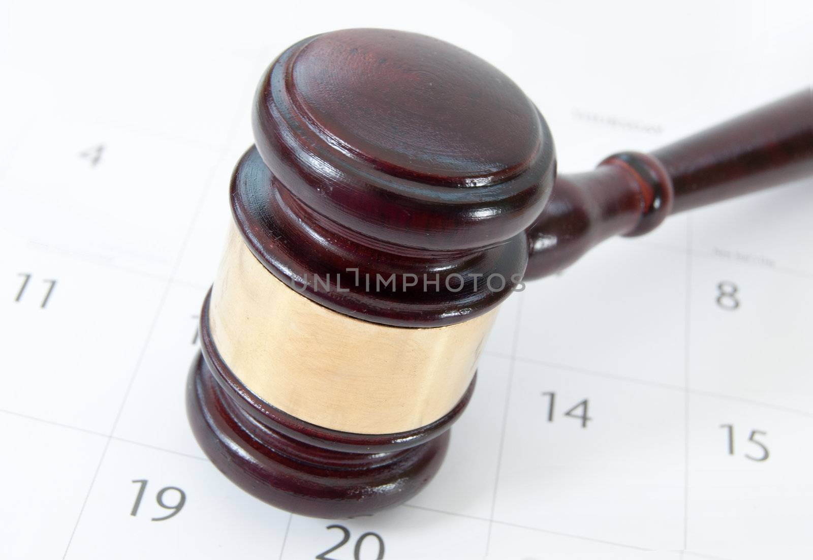 Closeup of a wooden gavel on top  of a calendar page