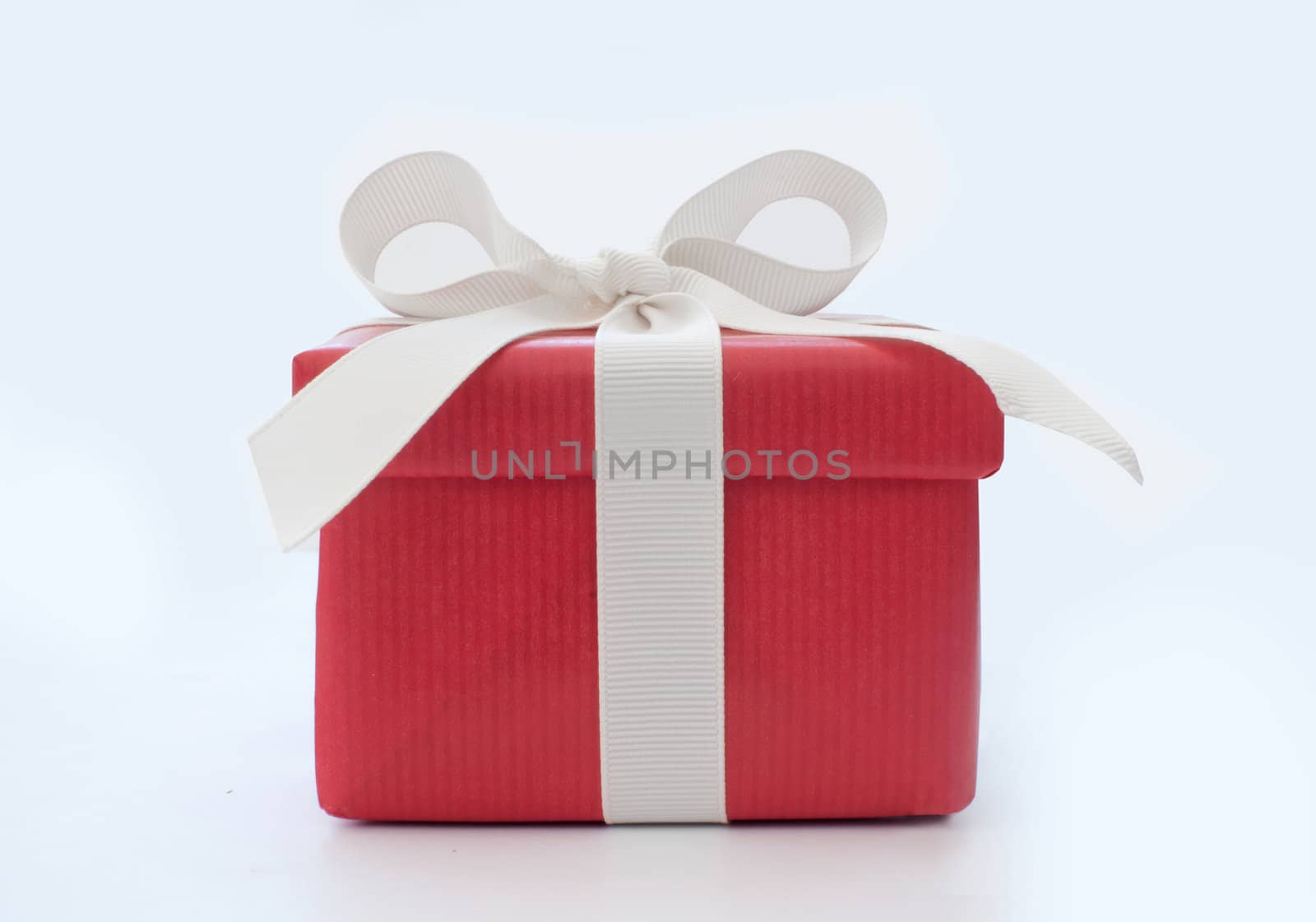 Red gift box tied with a white ribbon bow