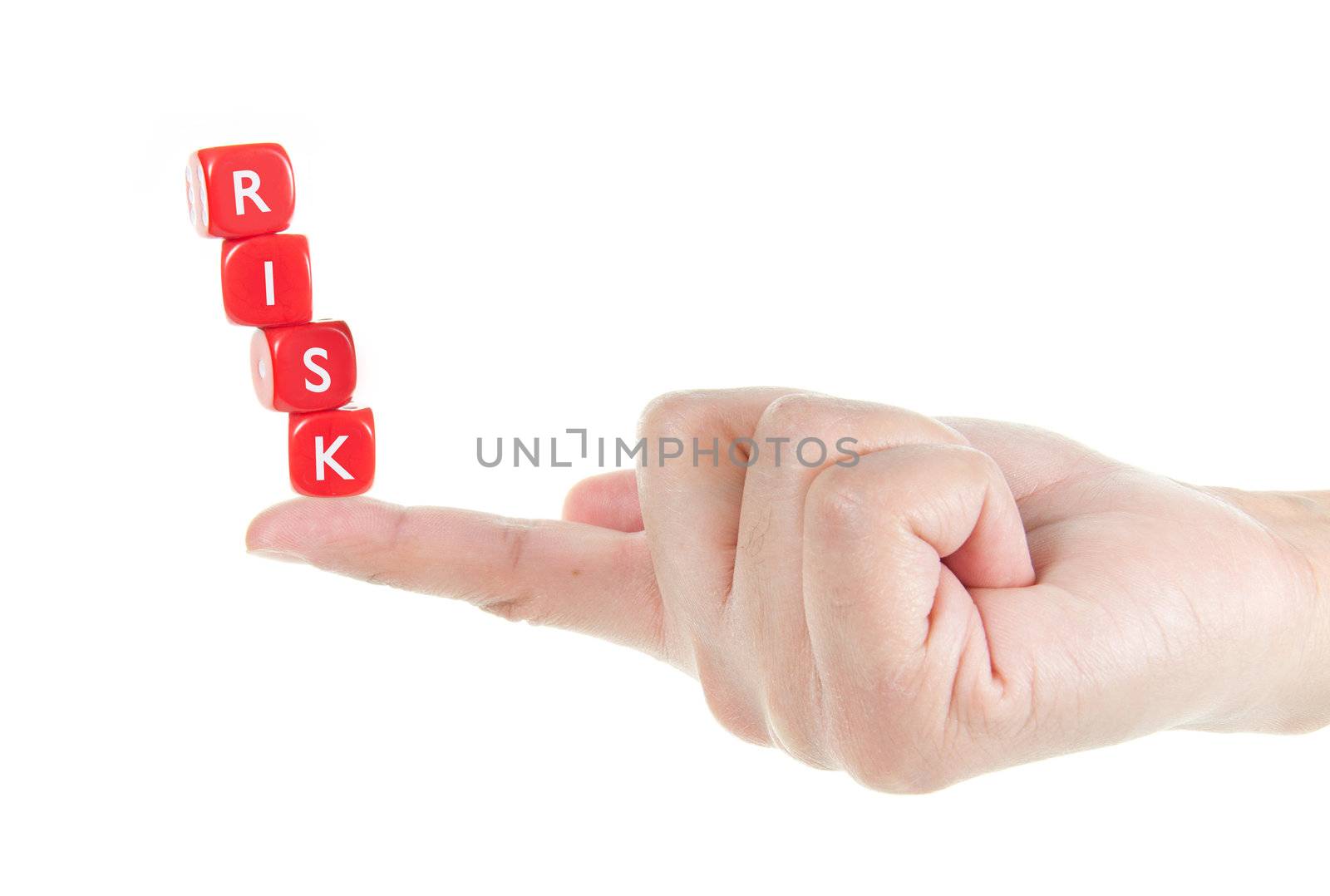 Dice labelled risk balanced on a finger tip  
