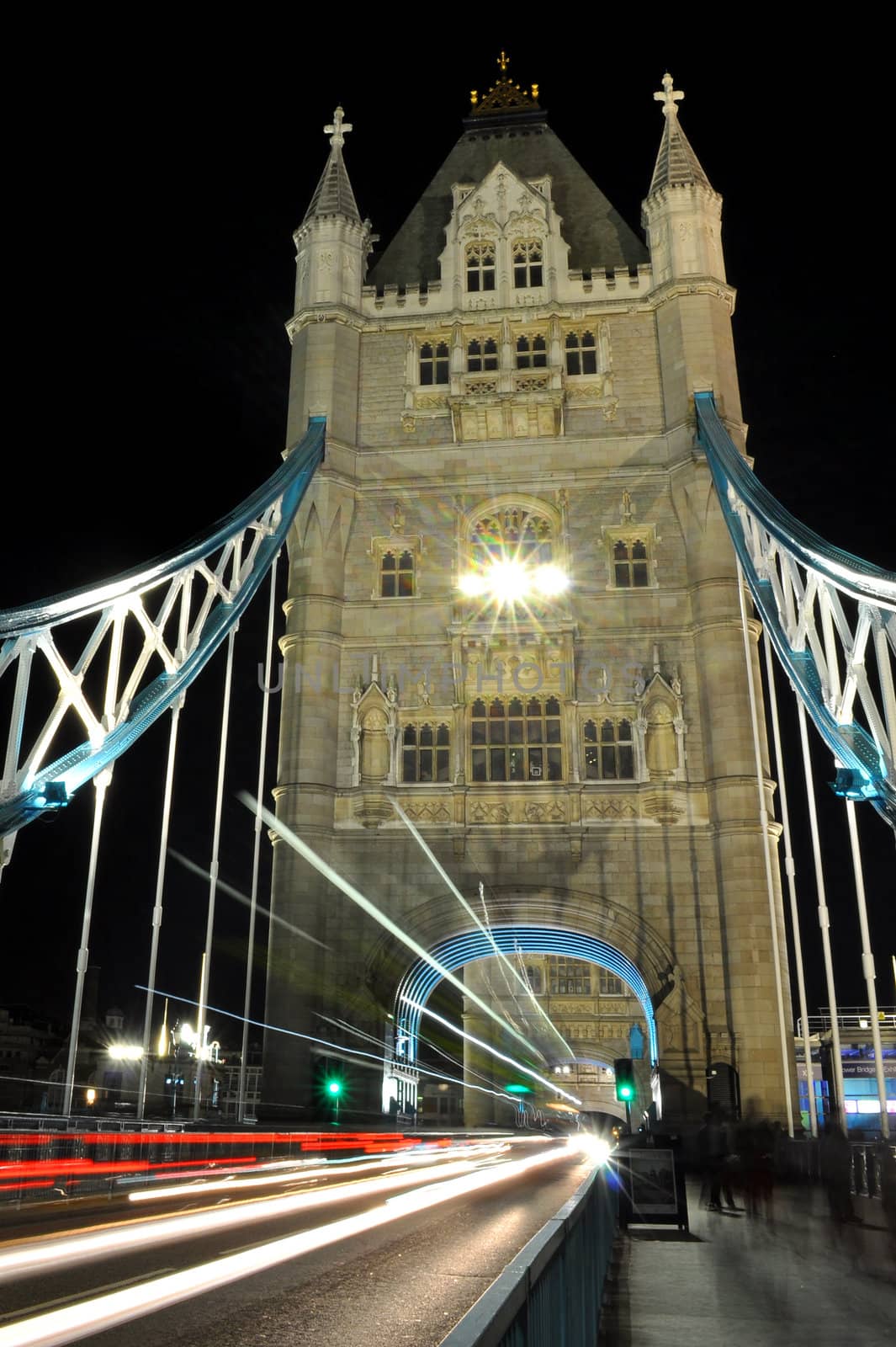 Closeup of Tower Bridge with traffic passing at night time 