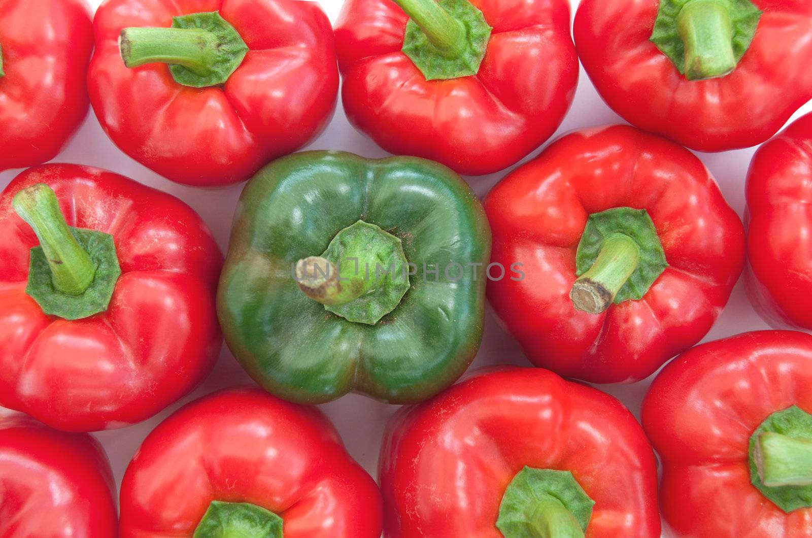 Green amongst many red peppers