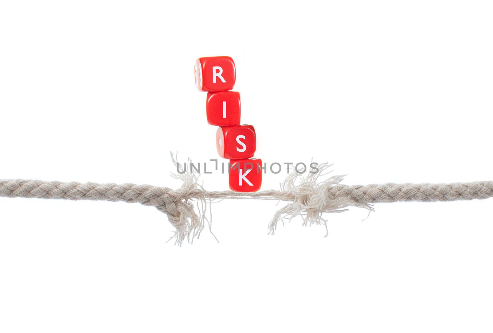 Dice labelled risk balanced on breaking rope