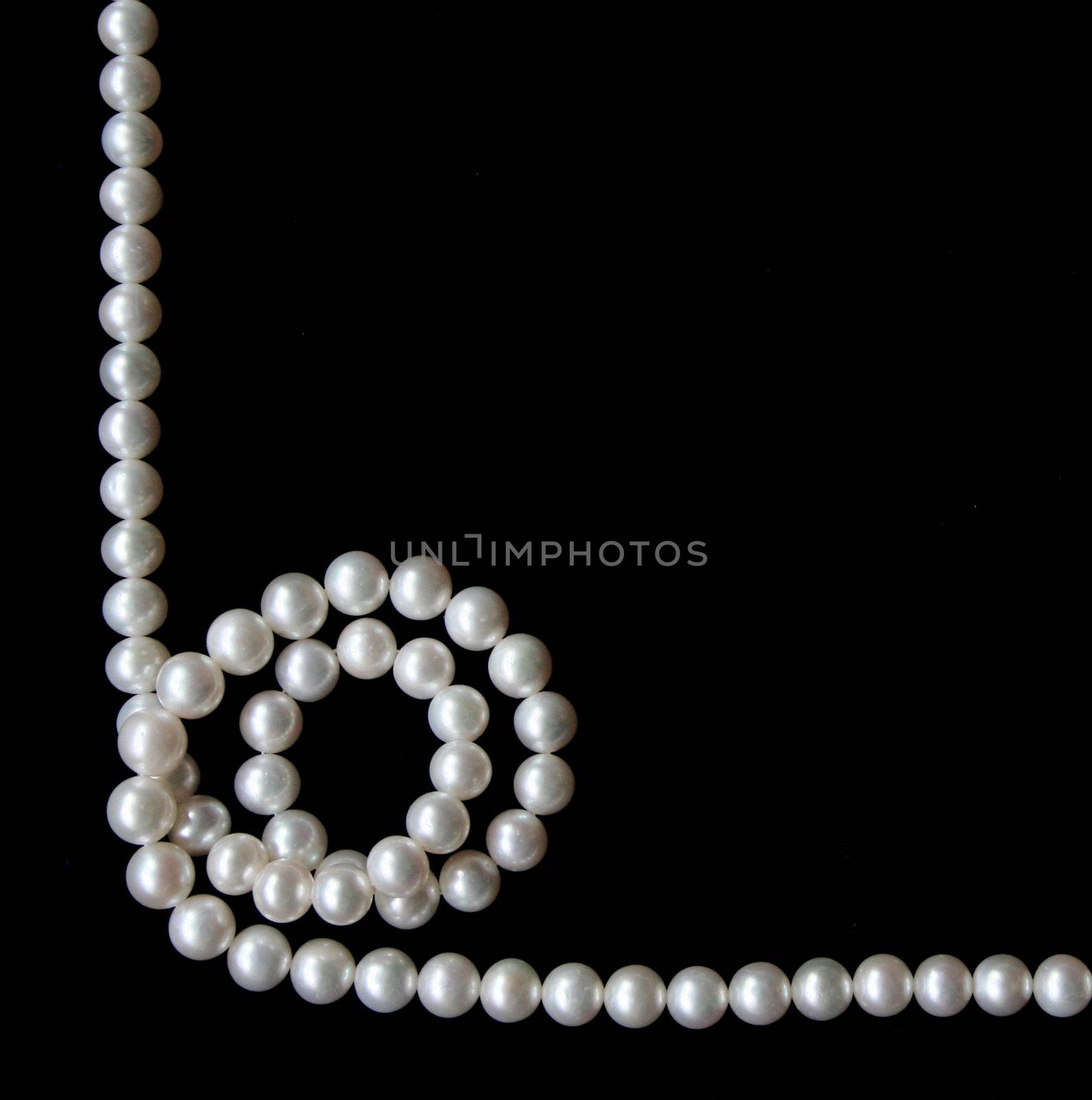 White pearls on the black velvet background 