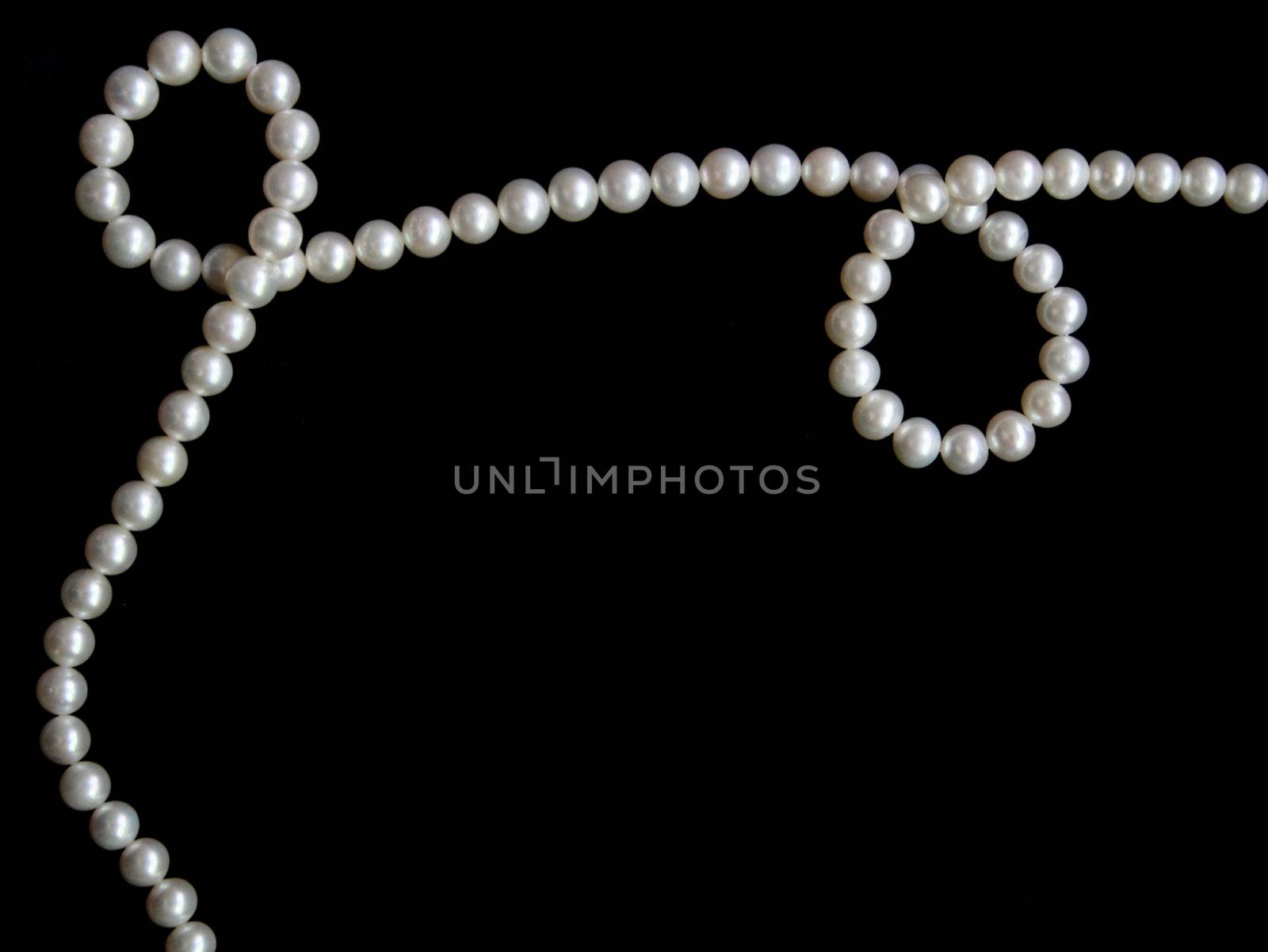White pearls on the black velvet background 