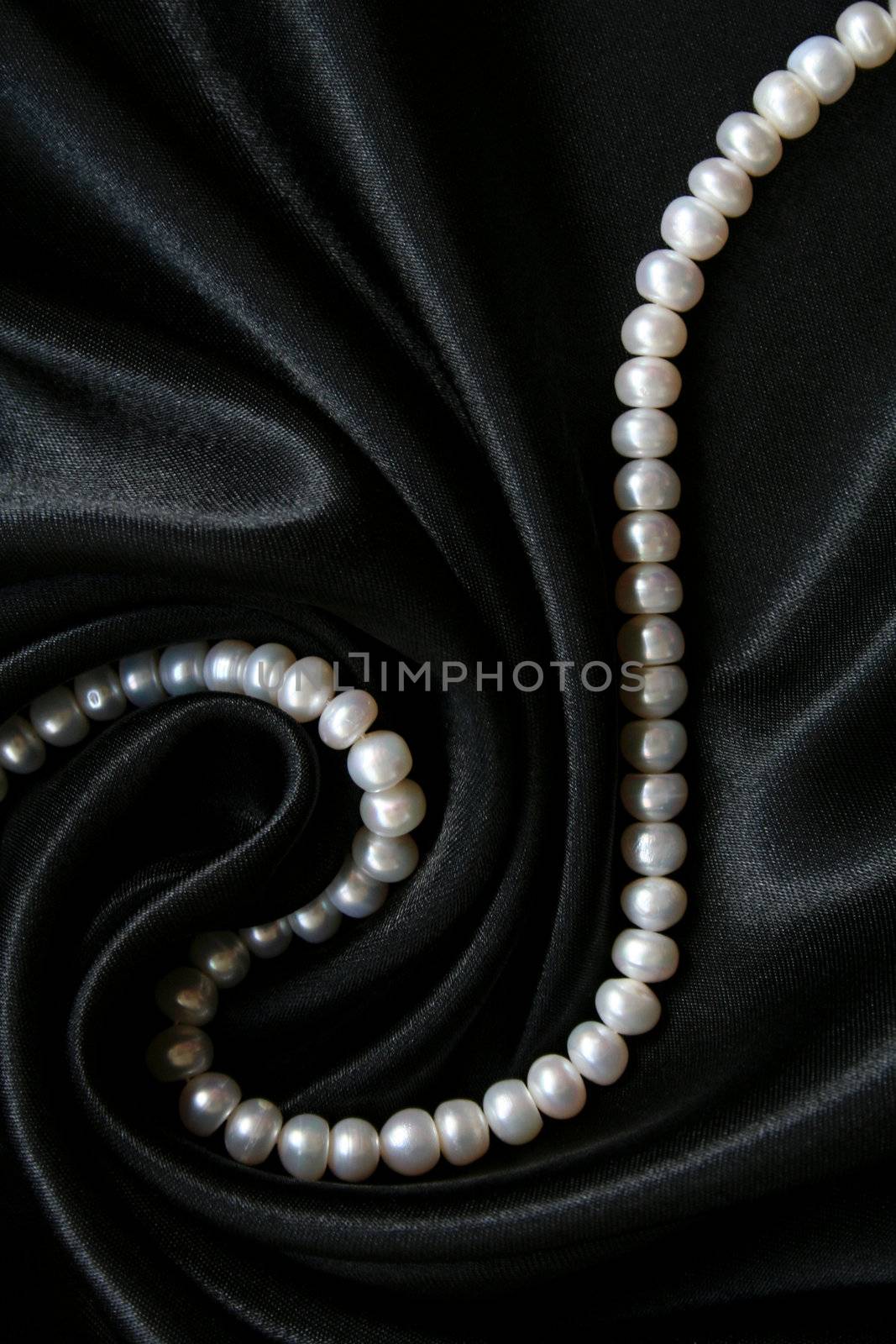 White pearls on the black silk can use as background 