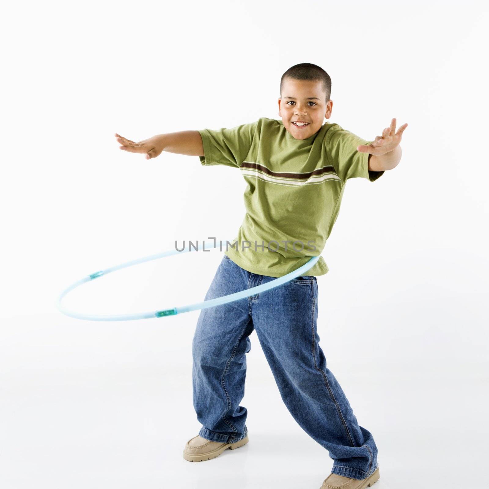Boy using hula hoop. by iofoto