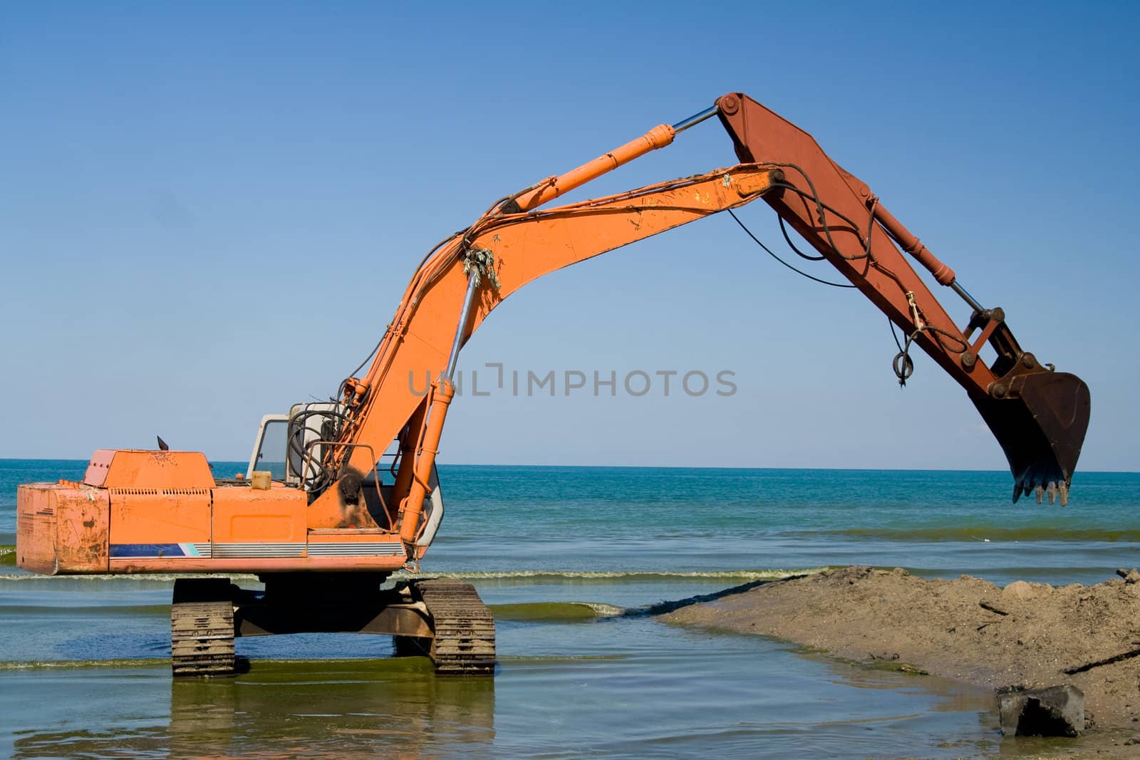 Orange Excavator on the beach