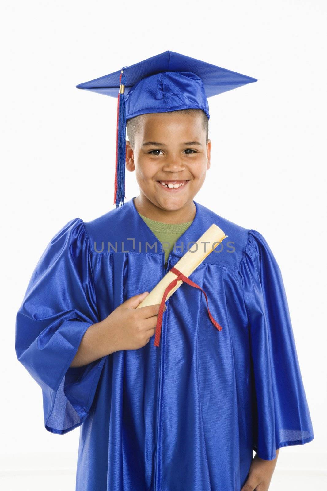 Young boy wearing blue graduation gown holding diploma.