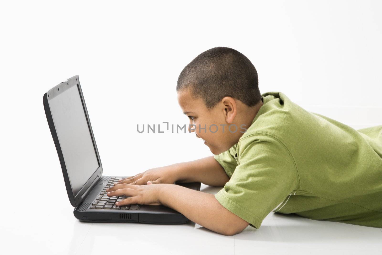 Young latino boy using laptop computer.